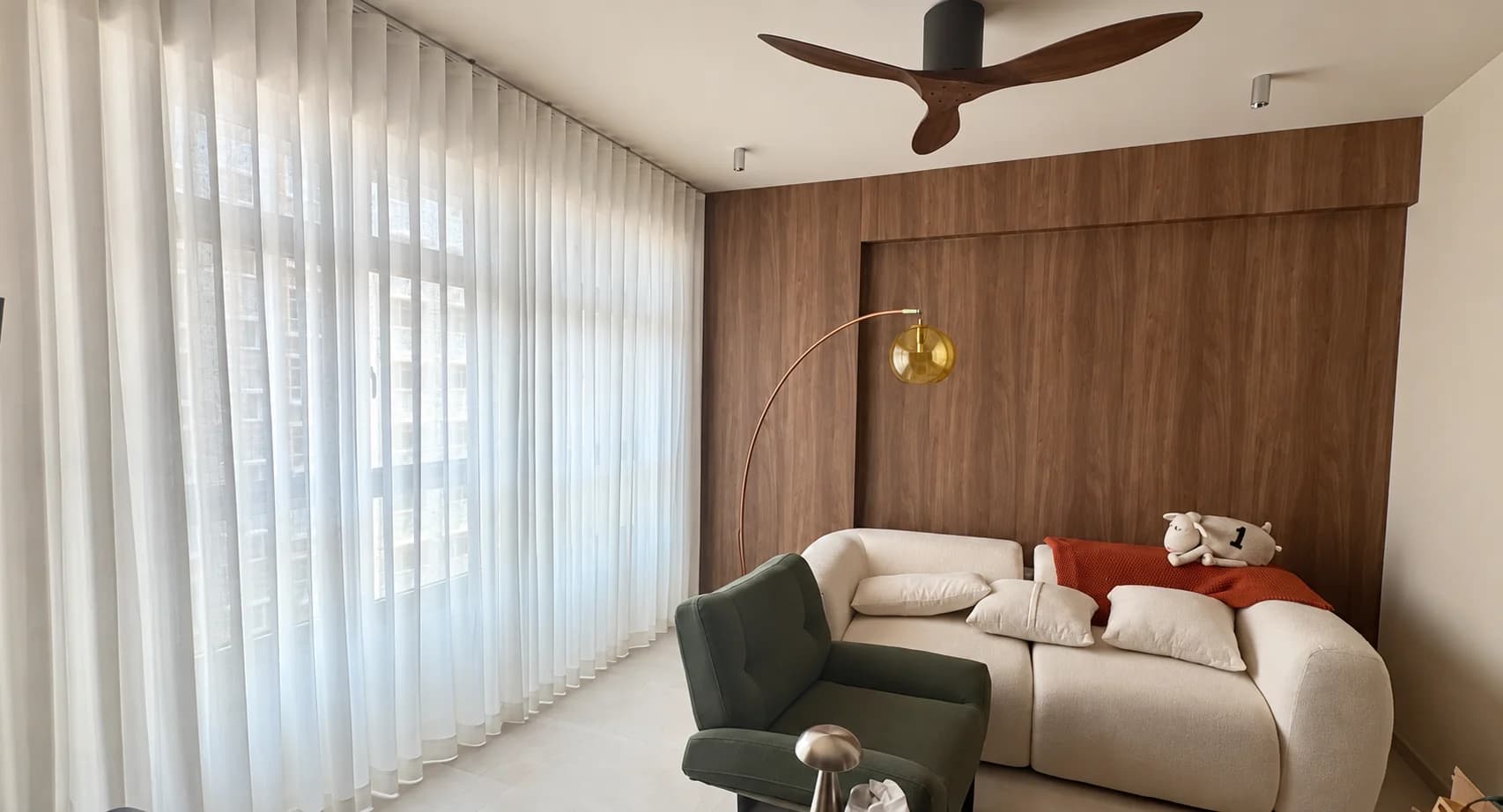 Sheer S-fold curtains drawn beside a living room window