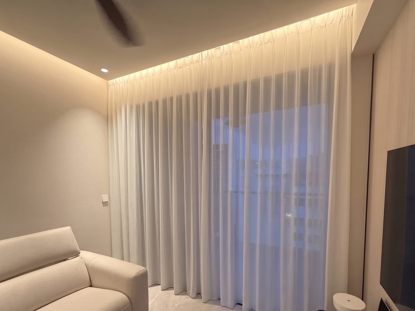 Sheer day curtains across a living room window