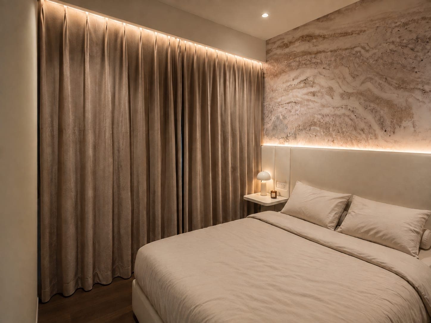 The bedroom styled at night, taupe pinch-pleat night curtains drawn closed across the full wall beside a travertine feature wall and upholstered headboard