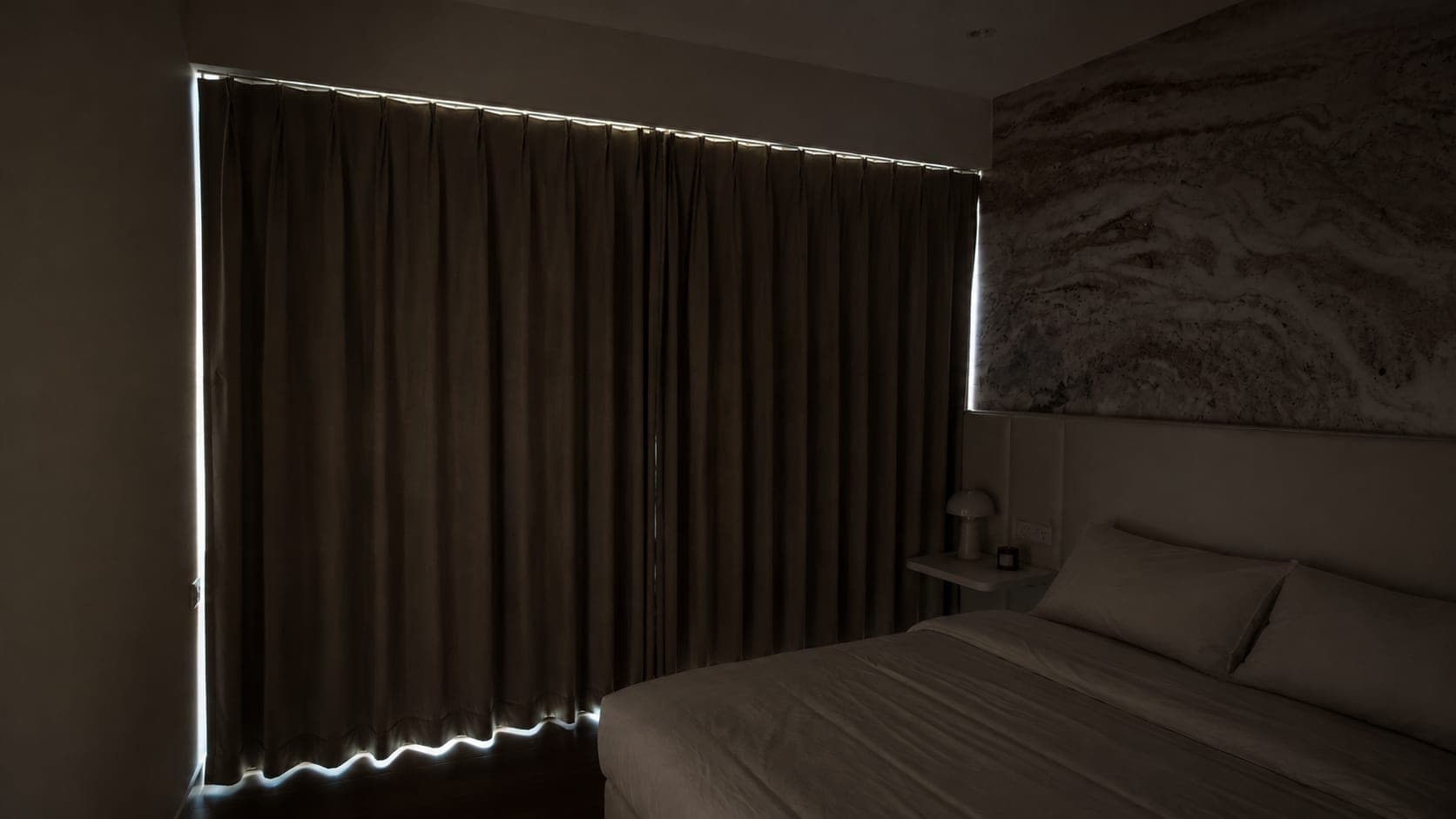 The bedroom at night with the night curtains closed and the room lights off