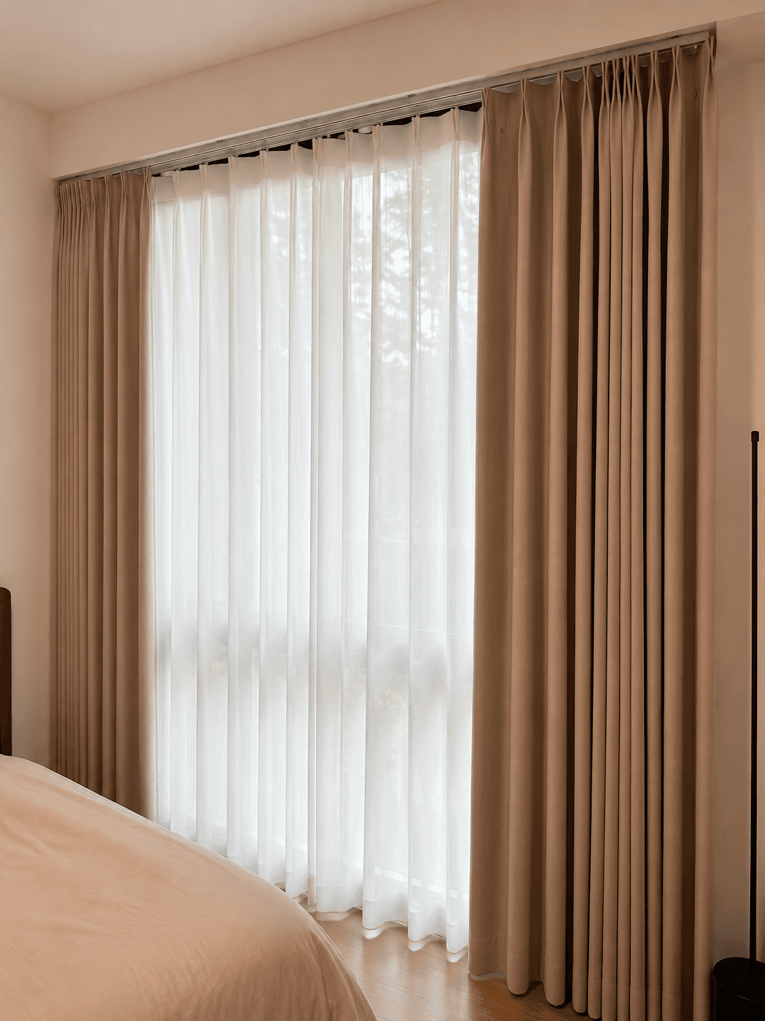 Layered day and night curtains in a bedroom